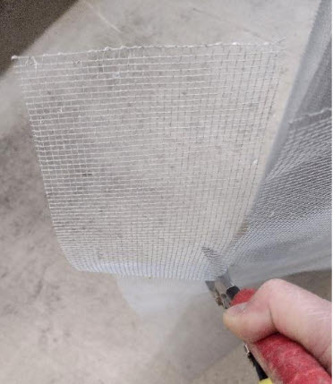 Hardwire cloth being cut with snips.